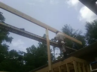 Carpenter setting a ridge beam over a new addition frame — Ice Dam Removal by Roofing Brothers in Coudersport
