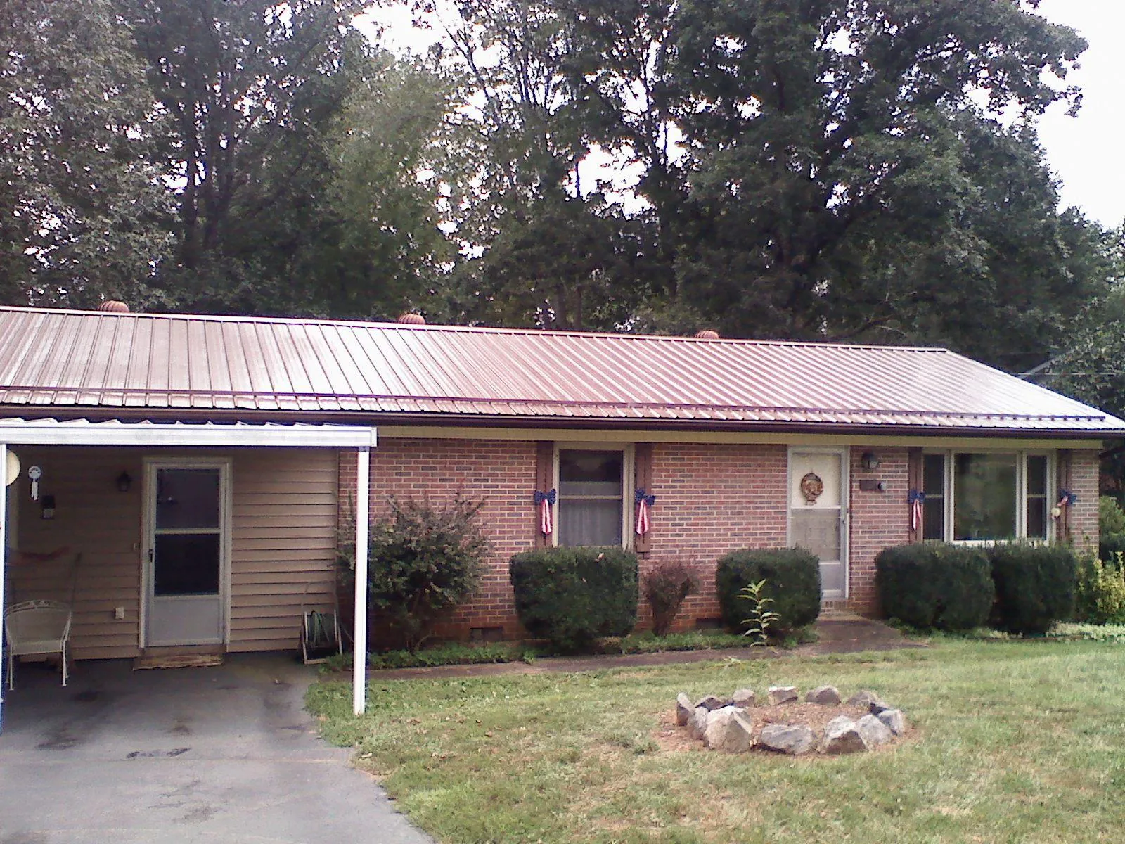 Bronze metal roof and carport on a brick ranch home — Roof Repair work by our crew in Coudersport